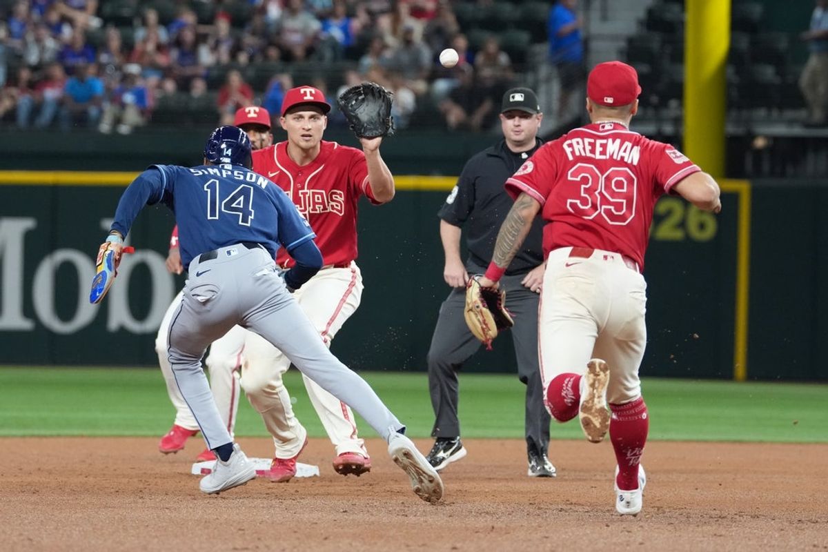 Sep 4, 2026; Arlington, Texas, USA;  Tampa Bay Rays left fielder Chandler Simpson (14) is caught in a run-down by Texas Rangers shortstop Corey Seager (5) and third baseman Cody Freeman (39) during the fifth inning at Globe Life Field.  Mandatory Credit: Jim Cowsert-Imagn Images