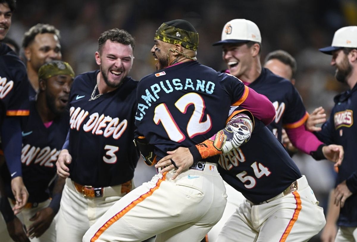 Sep 4, 2026; San Diego, California, USA;  San Diego Padres catcher Luis Campusano (12), center, celebrates with teammates after hitting a walk-off home run during the tenth inning against the New York Yankees at Petco Park.  Mandatory Credit: Denis Poroy-Imagn Images