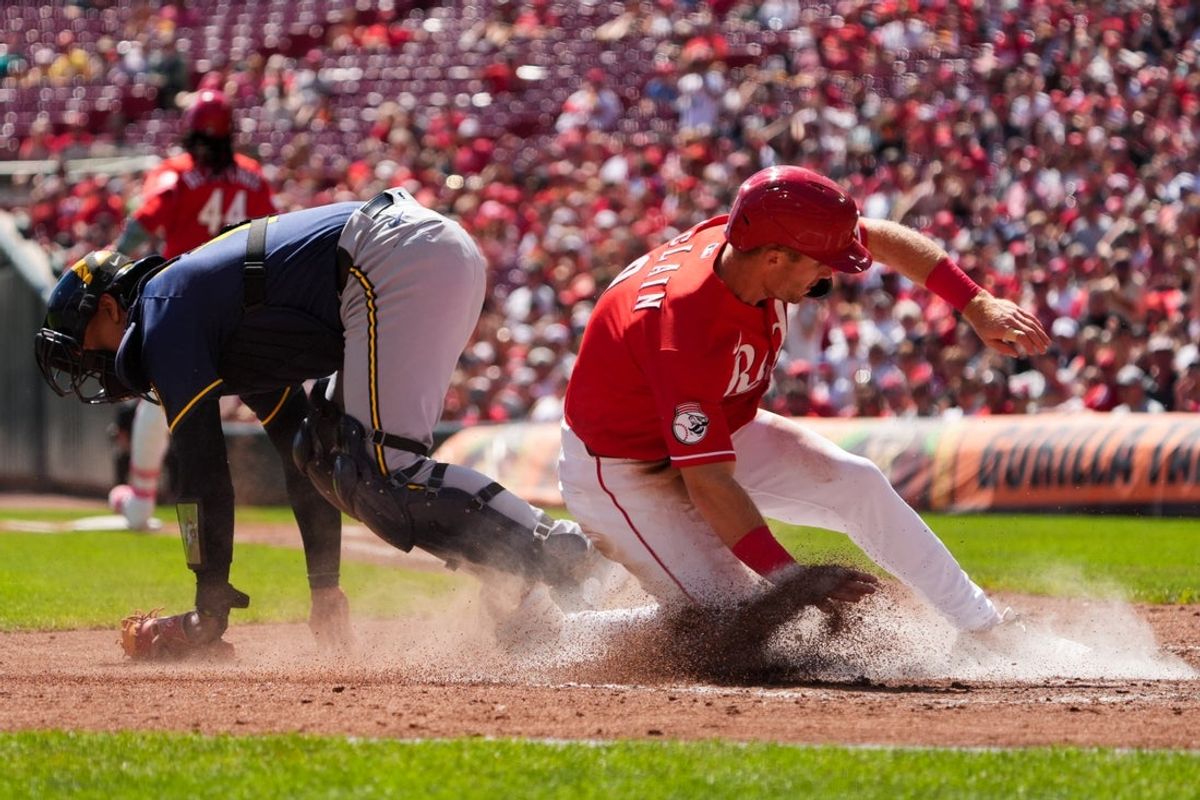 Sep 6, 2026; Cincinnati, Ohio, USA;  Cincinnati Reds second baseman Matt McLain scores a run ahead of the play by Milwaukee Brewers catcher Bo Naylor in the second inning at Great American Ball Park. Mandatory Credit: Aaron Doster-Imagn Images