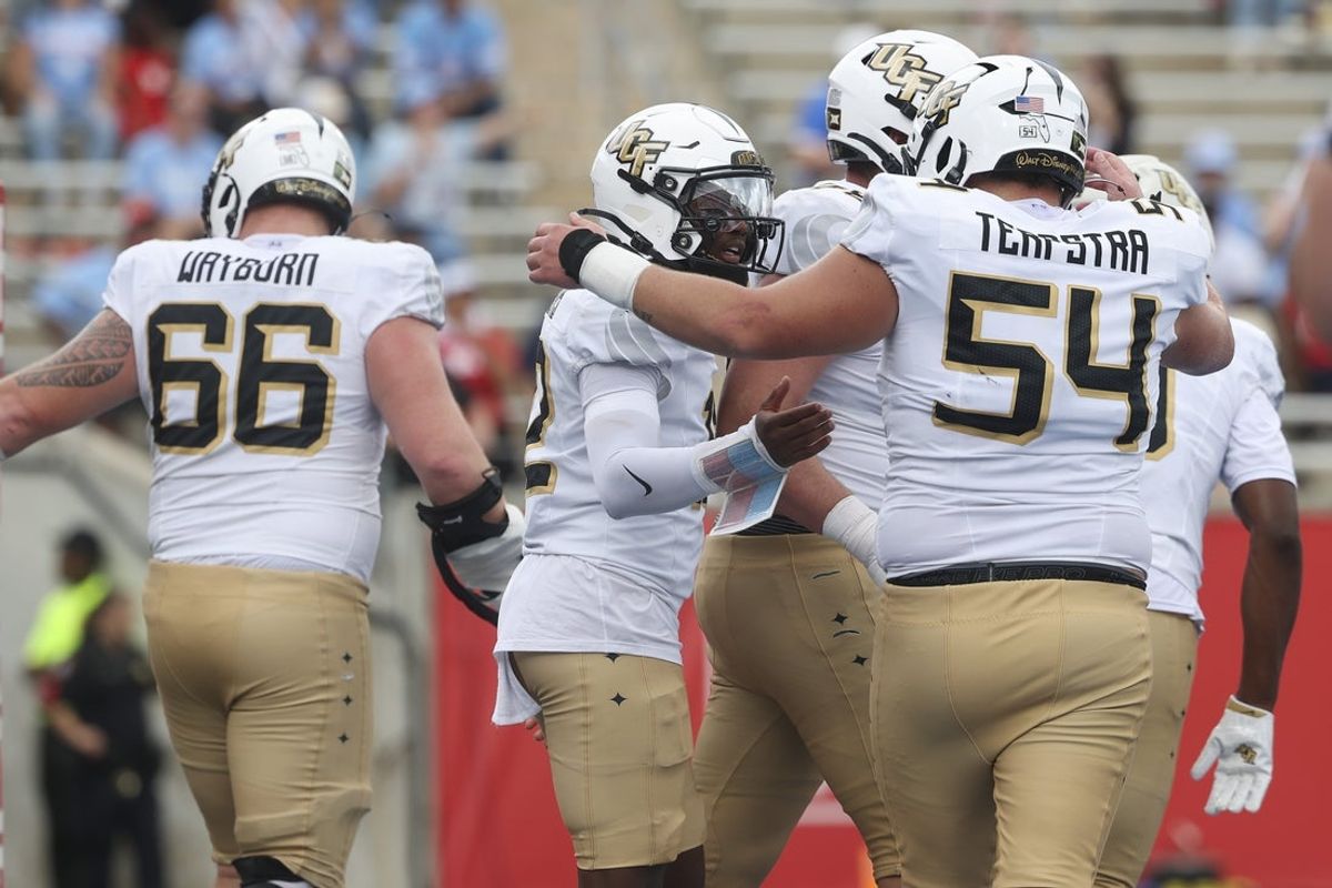 Oct 3, 2026; Houston, Texas, USA; UCF Knights quarterback Keyone Jenkins (12) celebrates with offensive lineman Cooper Terpstra (54) after scoring a touchdown during the third quarter against the Houston Cougars at TDECU Stadium. Mandatory Credit: Troy Taormina-Imagn Images
