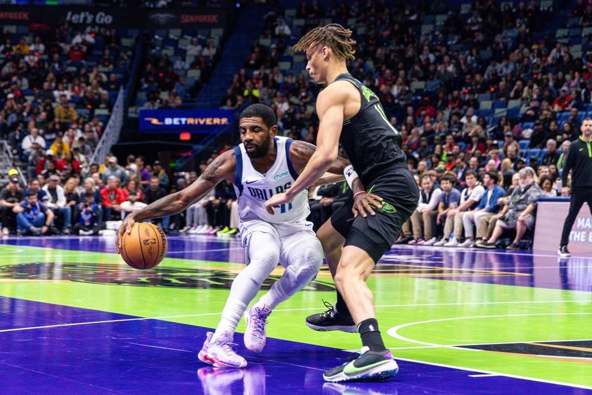 Nov 14, 2023; New Orleans, Louisiana, USA;  Dallas Mavericks guard Kyrie Irving (11) dribbles around New Orleans Pelicans guard Dyson Daniels (11) during the first half at the Smoothie King Center.