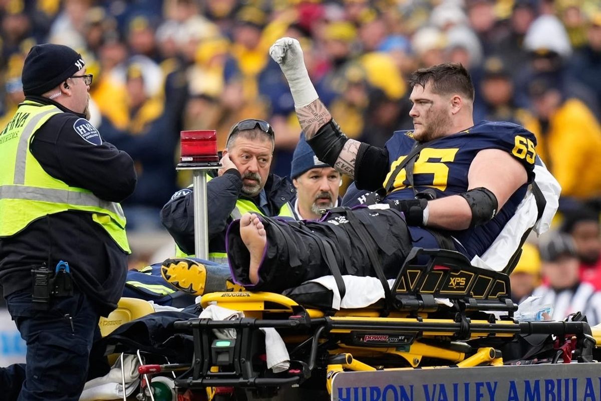 Nov 25, 2023; Ann Arbor, Michigan, USA; Michigan Wolverines offensive lineman Zak Zinter (65) is carted off by medics after an injury during the second half of the NCAA football game against the Michigan Wolverines at Michigan Stadium. Ohio State lost 30-24.