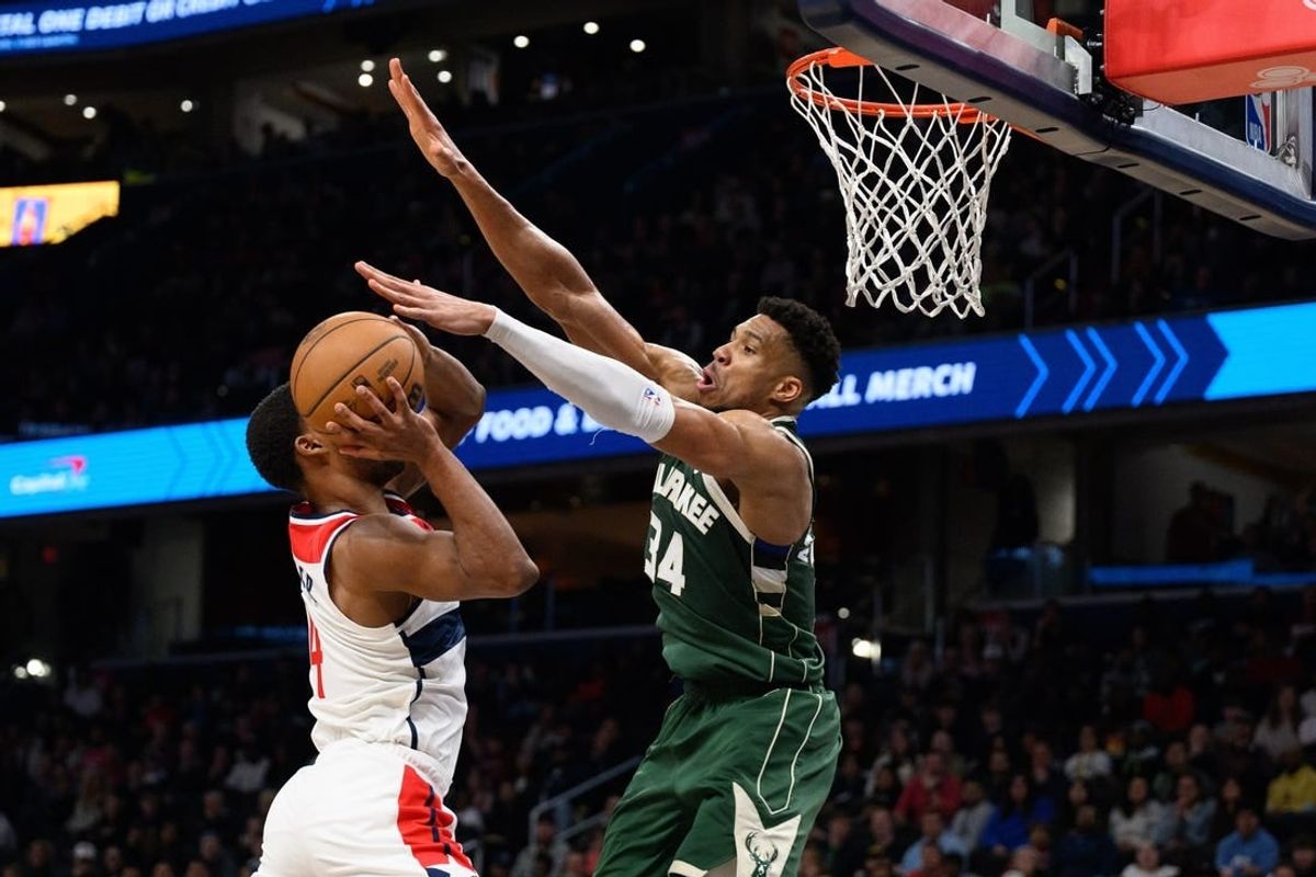 Apr 2, 2024; Washington, District of Columbia, USA; Milwaukee Bucks forward Giannis Antetokounmpo (34) defends against Washington Wizards guard Jared Butler (4) during the fourth quarter at Capital One Arena.