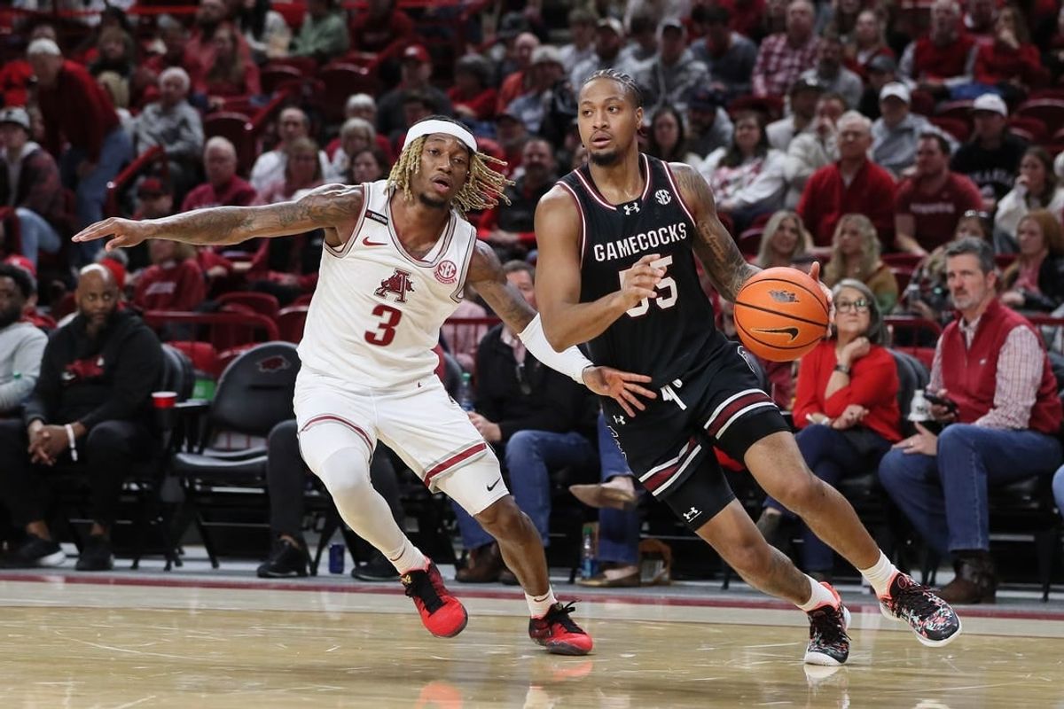 Jan 20, 2024; Fayetteville, Arkansas, USA; South Carolina Gamecocks guard Ta Lon Cooper (55) dribbles by Arkansas Razorbacks guard El Ellis (3) during the second half at Bud Walton Arena. Gamecocks won 77-64.