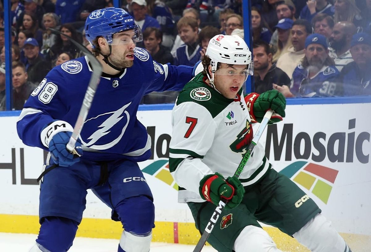Jan 18, 2024; Tampa, Florida, USA; Tampa Bay Lightning left wing Brandon Hagel (38) ands Minnesota Wild defenseman Brock Faber (7) skate after the puck during the first period at Amalie Arena.