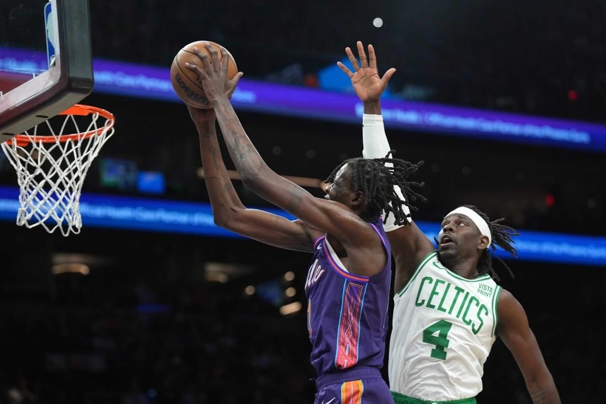 Mar 9, 2024; Phoenix, Arizona, USA; Phoenix Suns center Bol Bol (11) puts up a layup over Boston Celtics guard Jrue Holiday (4) during the first half at Footprint Center.
