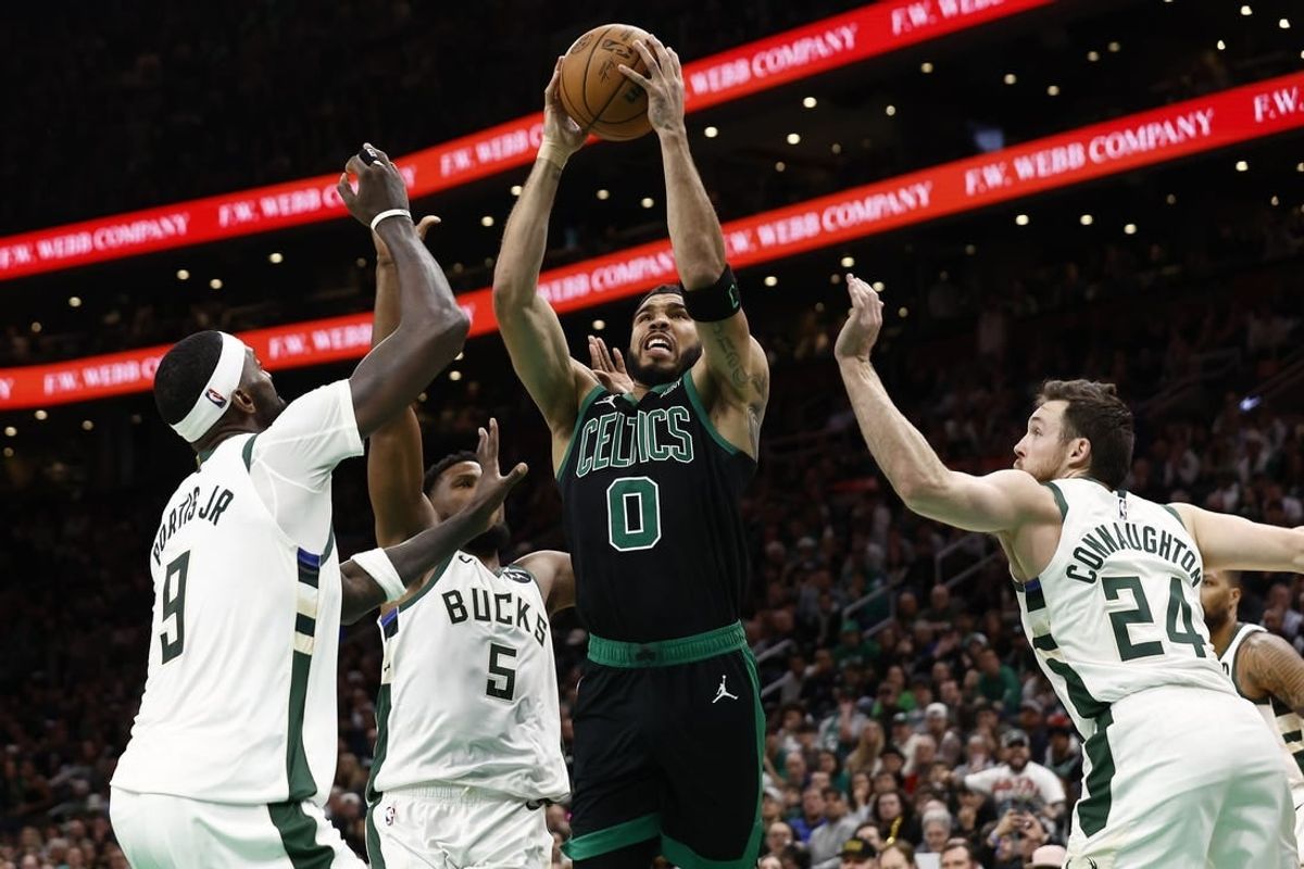 Mar 20, 2024; Boston, Massachusetts, USA; Boston Celtics forward Jayson Tatum (0) goes to the basket between Milwaukee Bucks guard Pat Connaughton (24) and forward Bobby Portis (9) during the second half at TD Garden.