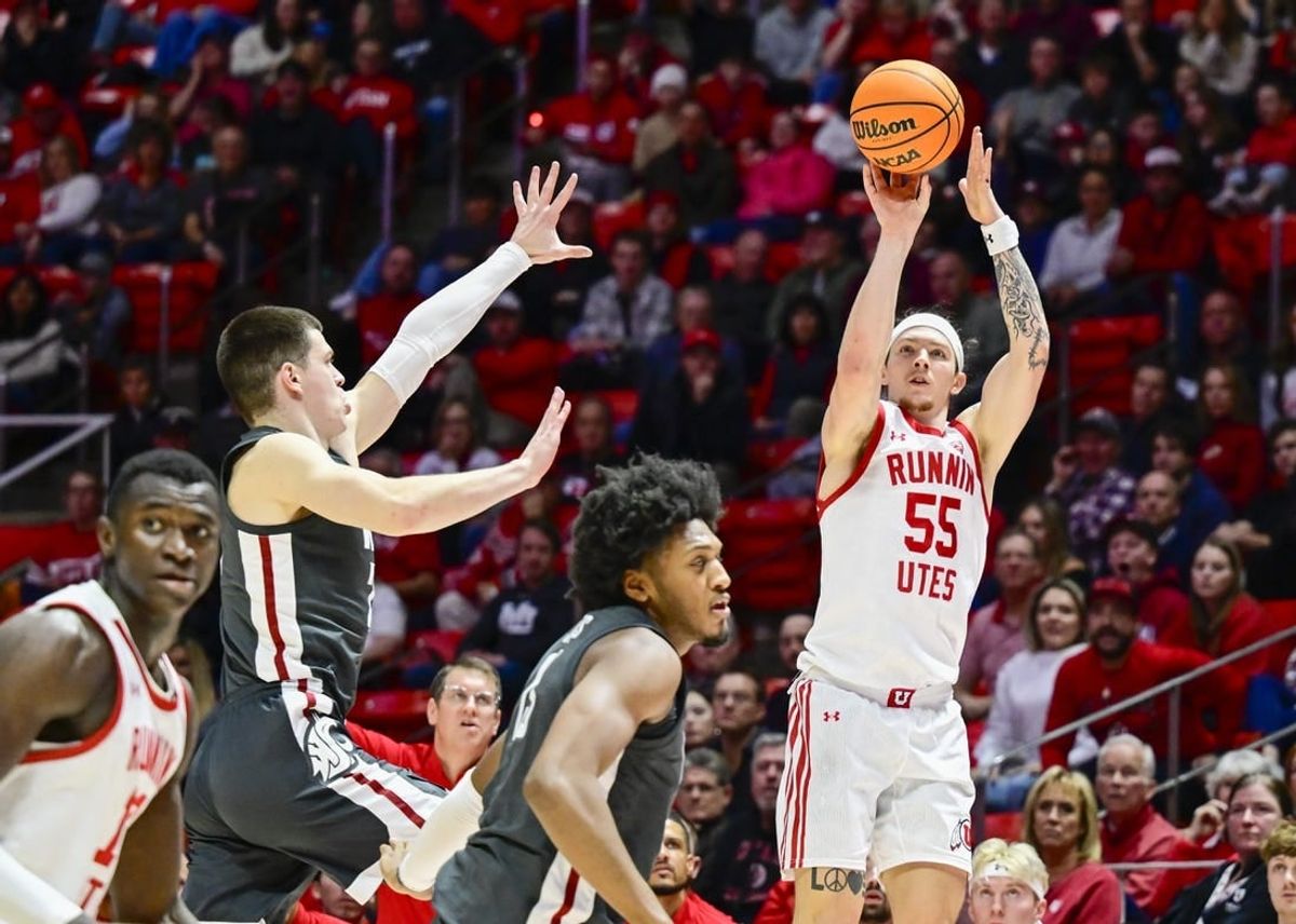 Dec 29, 2023; Salt Lake City, Utah, USA; Utah Utes guard Gabe Madsen (55) takes a three point shot over Washington State Cougars forward Andrej Jakimovski (23) during the second half at the Jon M. Huntsman Center.