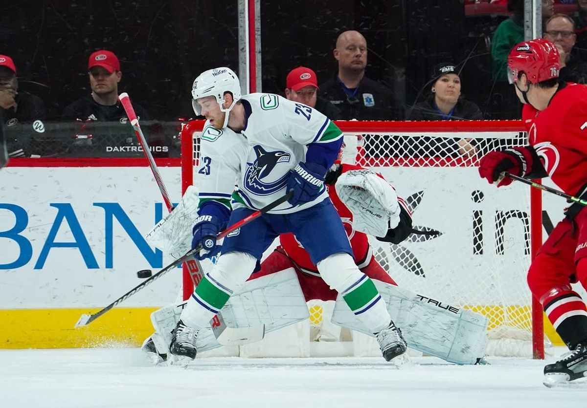 Feb 6, 2024; Raleigh, North Carolina, USA; Vancouver Canucks center Elias Lindholm (23) tips the puck past Carolina Hurricanes goaltender Pyotr Kochetkov (52) for a goal during the first period at PNC Arena.
