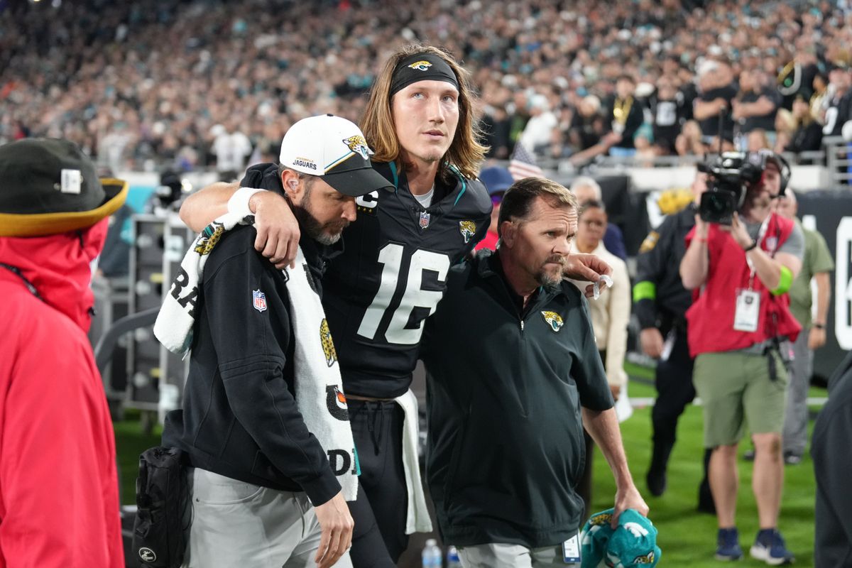 Trevor Lawrence is helped off the field Monday night.