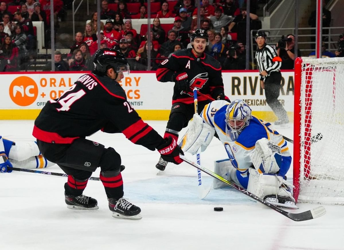 Dec 2, 2023; Raleigh, North Carolina, USA; Carolina Hurricanes center Sebastian Aho (20) sends the past to  center Seth Jarvis (24) past Buffalo Sabres goaltender Eric Comrie (31) during the first period at PNC Arena.