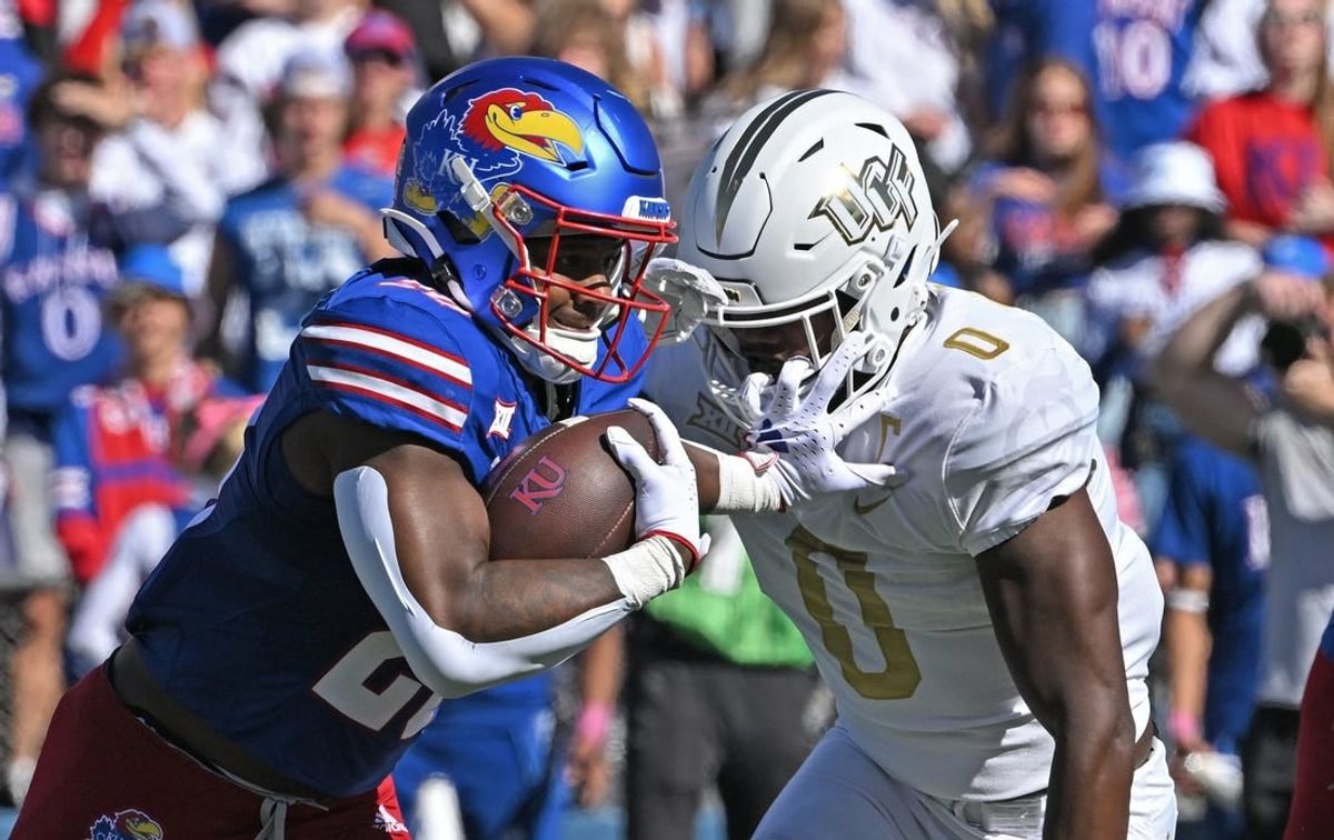 Oct 7, 2023; Lawrence, Kansas, USA;  Kansas Jayhawks running back Daniel Hishaw Jr. (20) runs up field against UCF Knights linebacker Jason Johnson (0) during the first half at David Booth Kansas Memorial Stadium.