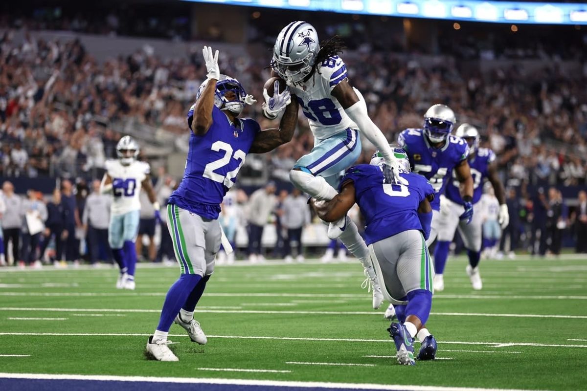 Nov 30, 2023; Arlington, Texas, USA; Dallas Cowboys wide receiver CeeDee Lamb (88) is tackled by Seattle Seahawks cornerback Tre Brown (22) and safety Quandre Diggs (6) during the first half at AT&T Stadium.
