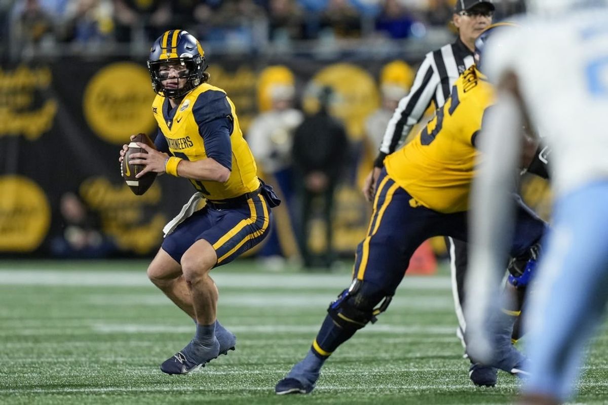 Dec 27, 2023; Charlotte, NC, USA; West Virginia Mountaineers quarterback Garrett Greene (6) in action during the first half at Bank of America Stadium.