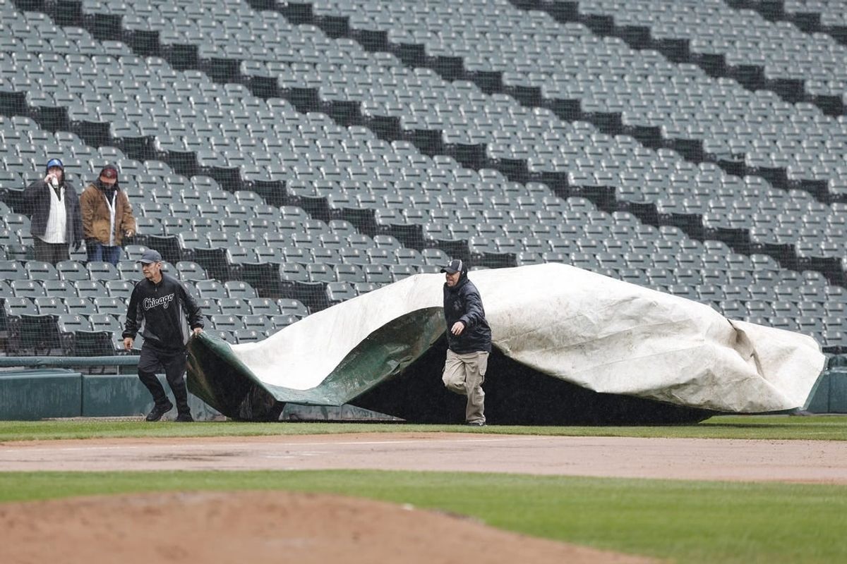 Apr 1, 2024; Chicago, Illinois, USA; Grounds crew covers the field with a tarp during a rain delay in the eight inning of a baseball game between the Chicago White Sox and Atlanta Braves at Guaranteed Rate Field.