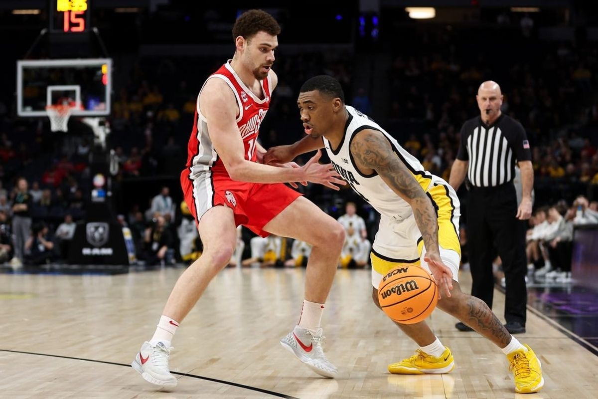 Mar 14, 2024; Minneapolis, MN, USA; Iowa Hawkeyes guard Tony Perkins (11) dribbles around Ohio State Buckeyes forward Jamison Battle (10) during the first half at Target Center.