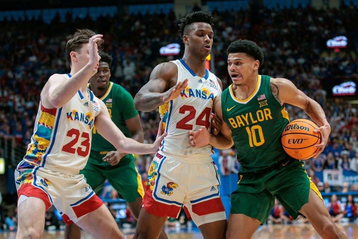 Feb 10, 2024; Lawrence, Kansas, USA; Baylor Bears guard RayJ Dennis (10) tries to get around Kansas Jayhawks forward K.J. Adams Jr. (24) and Kansas Jayhawks forward Parker Braun (23) during the first half at Allen Fieldhouse.