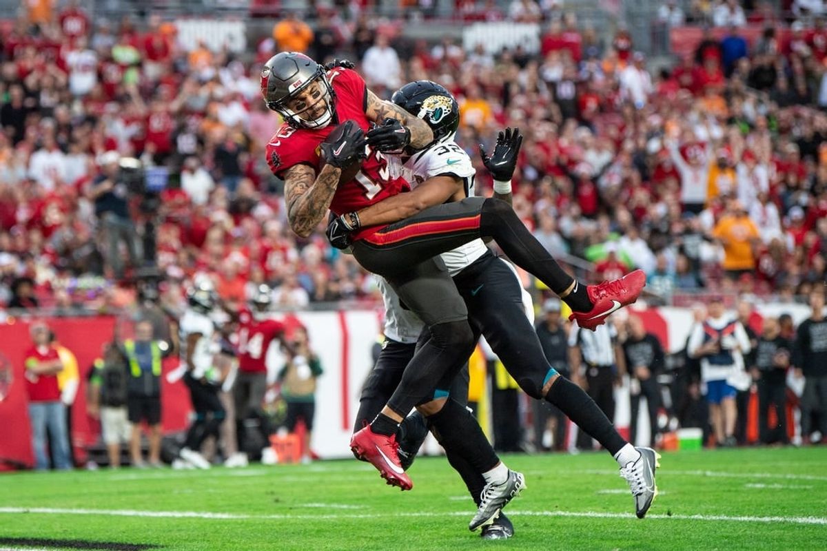 Dec 24, 2023; Tampa, Florida, USA; Tampa Bay Buccaneers wide receiver Mike Evans (13) makes the catch against Jacksonville Jaguars cornerback Tyson Campbell (32) in the second quarter for the touchdown at Raymond James Stadium.