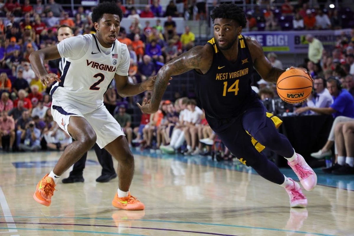 Nov 22, 2023; Fort Myers, FL, USA;  West Virginia Mountaineers guard Seth Wilson (14) drives past Virginia Cavaliers guard Reece Beekman (2) in the second half during the Fort Myers Tip-Off third place game at Suncoast Credit Union Arena.