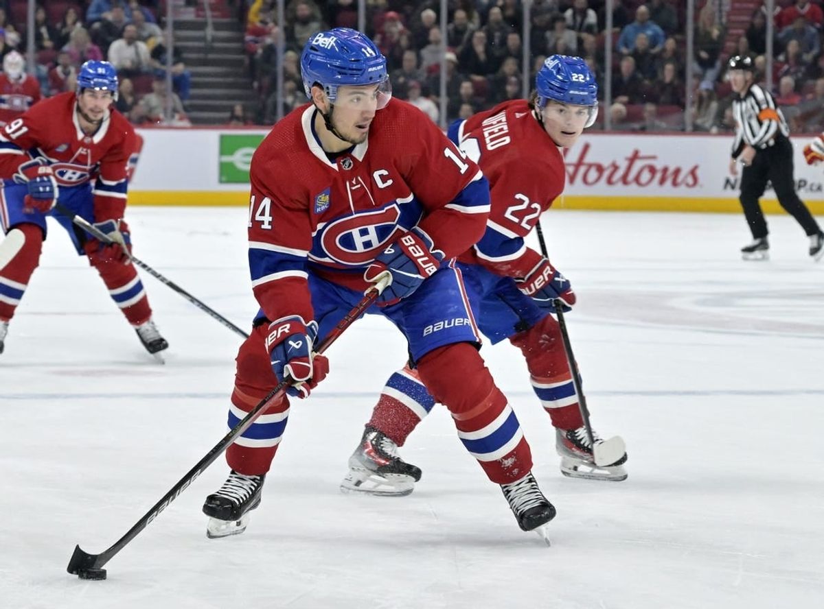 Nov 14, 2023; Montreal, Quebec, CAN; Montreal Canadiens forward Nick Suzuki (14) brings the puck in the Calgary Flames zone with the help of teammate forward Cole Caufield (22) during the third period at the Bell Centre.