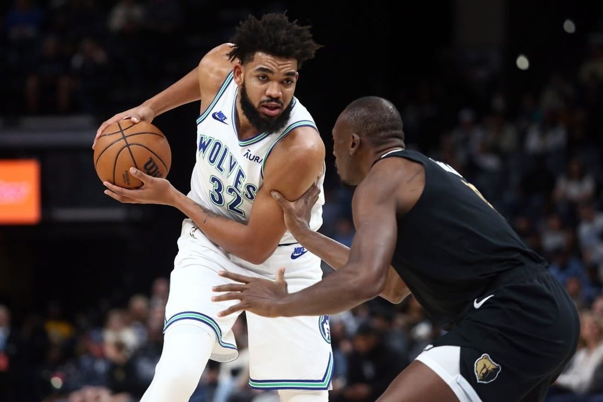 Dec 8, 2023; Memphis, Tennessee, USA; Minnesota Timberwolves center-forward Karl-Anthony Towns (32) handles the ball as Memphis Grizzlies center Bismack Biyombo (18) defends during the first half at FedExForum.