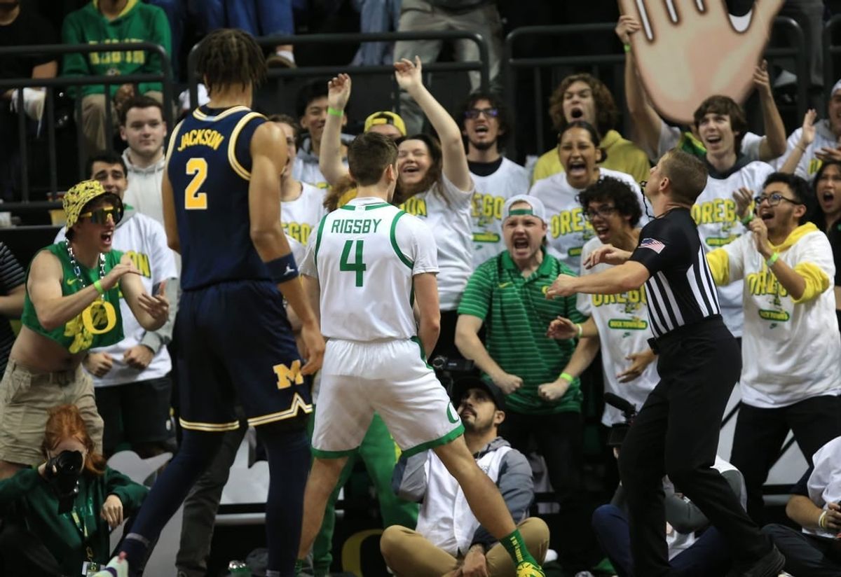 Oregon   s Brennan Rigsby, center, celebrates with Duck fans during the first half of their game against Michigan at Matthew Knight Arena in Eugene Saturday, Dec 2, 2023.