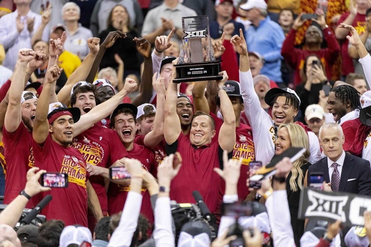 Mar 16, 2024; Kansas City, MO, USA; Iowa State Cyclones head coach TJ Otzelberger hoists the Big 12 Tournament trophy alongside his team after defeating the Houston Cougars at T-Mobile Center.