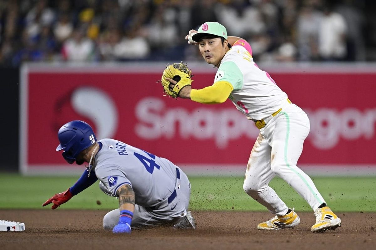 May 10, 2024; San Diego, California, USA; San Diego Padres shortstop Ha-Seong Kim (right) throws to first base late after forcing out Los Angeles Dodgers right fielder Andy Pages (44) at second base during the seventh inning at Petco Park.