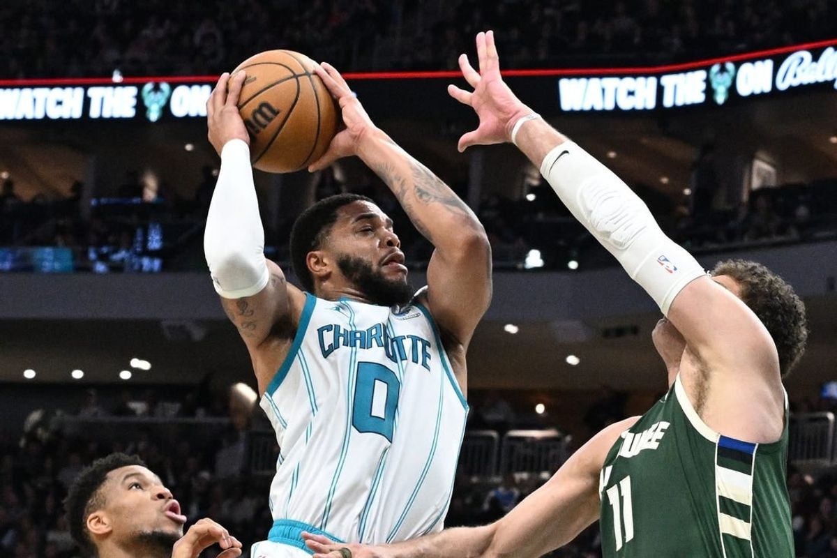 Feb 9, 2024; Milwaukee, Wisconsin, USA; Charlotte Hornets forward Miles Bridges (0) drives to the basket against Milwaukee Bucks center Brook Lopez (11) in the first half at Fiserv Forum.