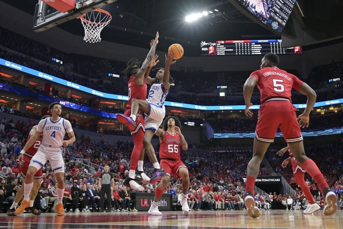 Dec 21, 2023; Louisville, Kentucky, USA;  Kentucky Wildcats guard Antonio Reeves (12) shoots against Louisville Cardinals guard Mike James (0) during the first half at KFC Yum! Center.