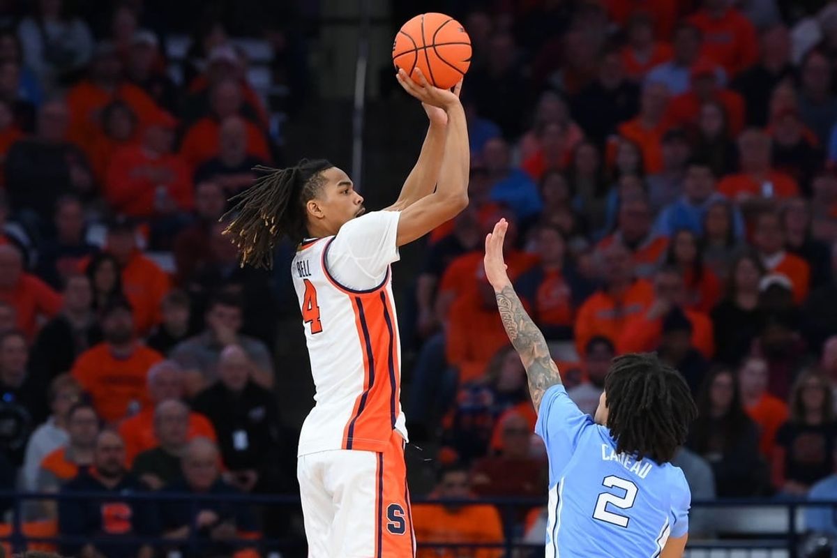 Feb 13, 2024; Syracuse, New York, USA; Syracuse Orange forward Chris Bell (4) shoots the ball against the defense of North Carolina Tar Heels guard Elliot Cadeau (2) during the first half at the JMA Wireless Dome.