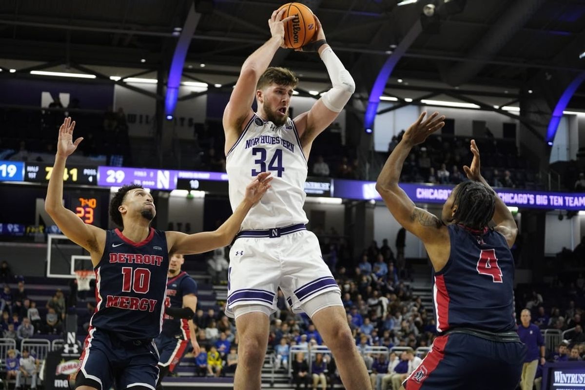 Dec 10, 2023; Evanston, Illinois, USA;Northwestern Wildcats center Matthew Nicholson (34) grabs a reboundd in front of Detroit Mercy Titans guard Marcus Tankersley (4) and  guard Jamail Pink (10) during the first half at Welsh-Ryan Arena.