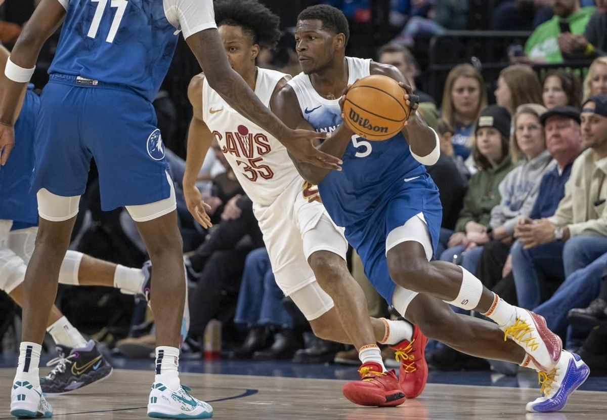 Mar 22, 2024; Minneapolis, Minnesota, USA; Minnesota Timberwolves guard Anthony Edwards (5) receives the ball from Minnesota Timberwolves center Naz Reid (11) against the Cleveland Cavaliers in the first half at Target Center.