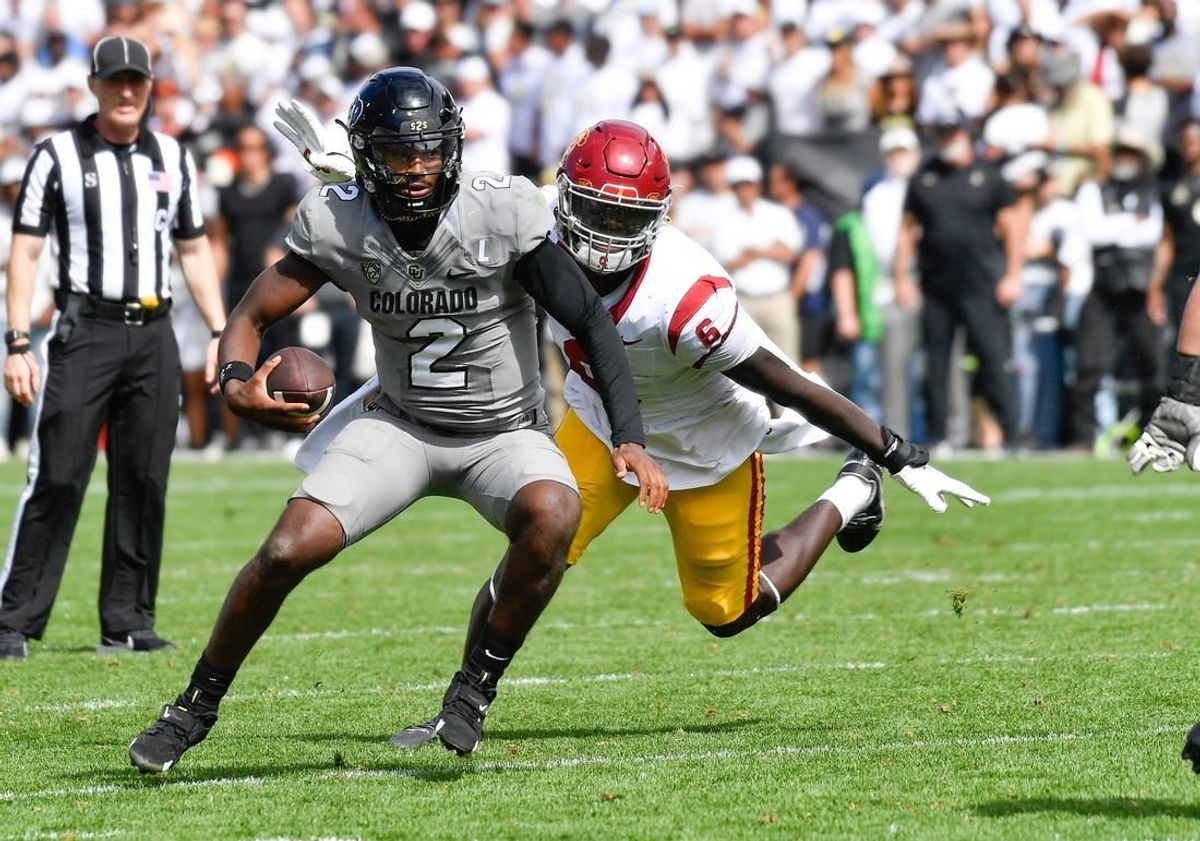 Sep 30, 2023; Boulder, Colorado, USA; Colorado Buffaloes quarterback Shedeur Sanders (2) attempts to scramble from USC Trojans defensive lineman Anthony Lucas (6) during the fourth quarter at Folsom Field.