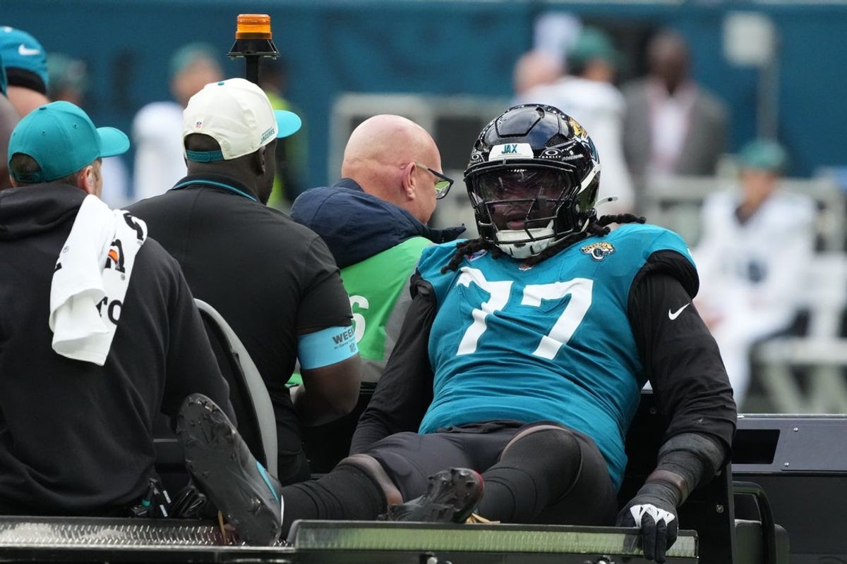 Oct 11, 2026; Tottenham, ENG;  Jacksonville Jaguars offensive line Anton Harrison (77) is carted off the field after an injury during the second half against the Philadelphia Eagles at Tottenham Hotspur Stadium.  Mandatory Credit: Kirby Lee-Imagn Images