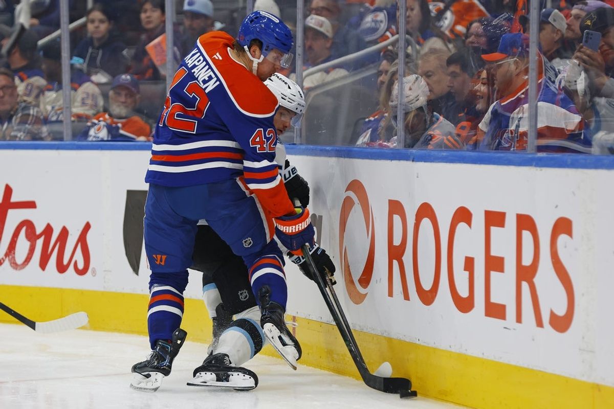 Oct 15, 2026; Edmonton, Alberta, CAN;  Edmonton Oilers forward Kasperi Kapanen (42) and Utah Mammoth forward Nick Schmaltz (8) battle along the boards for a loose puck  during the third period at Rogers Place.  Mandatory Credit: Perry Nelson-Imagn Images