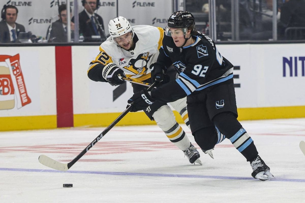 Oct 19, 2026; Salt Lake City, Utah, USA;  Utah Mammoth center Logan Cooley (92) skates with the puck against Pittsburgh Penguins defenseman Declan Carlile (72) during the third period at Delta Center.  Mandatory Credit: Rob Gray-Imagn Images