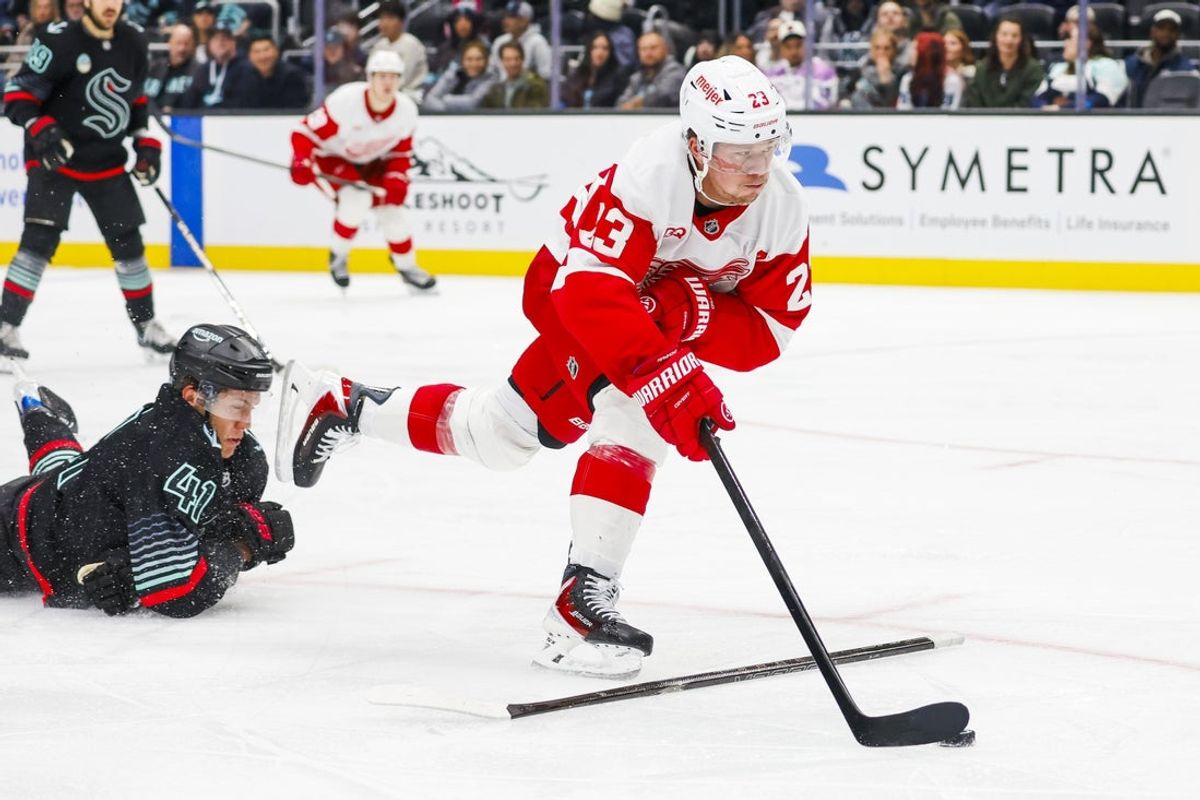 Oct 20, 2026; Seattle, Washington, USA; Detroit Red Wings left wing Lucas Raymond (23) skates with the puck ahead of Seattle Kraken defenseman Ryker Evans (41) during the third period at Climate Pledge Arena. Mandatory Credit: Joe Nicholson-Imagn Images