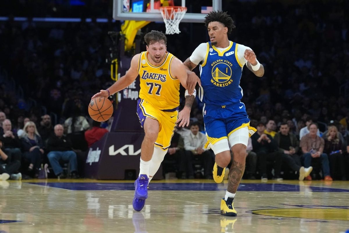 Oct 21, 2026; Los Angeles, California, USA; Los Angeles Lakers guard Luka Doncic (77) drives to the basket against Golden State Warriors forward Yaxel Lendeborg (1) in the first half at Crypto.com Arena. Mandatory Credit: Kirby Lee-Imagn Images