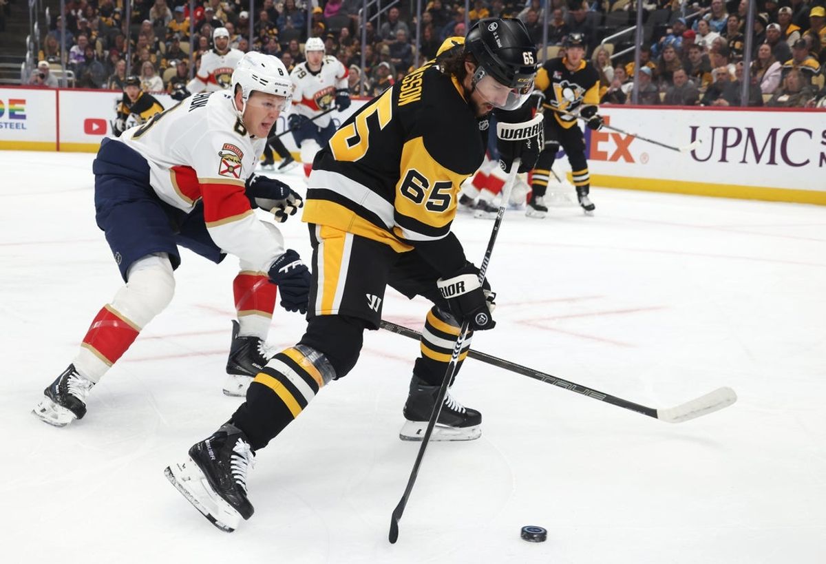 Oct 22, 2026; Pittsburgh, Pennsylvania, USA;  Pittsburgh Penguins defenseman Erik Karlsson (65) moves the puck against Florida Panthers left wing Brady Tkachuk (8) during the first period at PPG Paints Arena.  Mandatory Credit: Charles LeClaire-Imagn Images