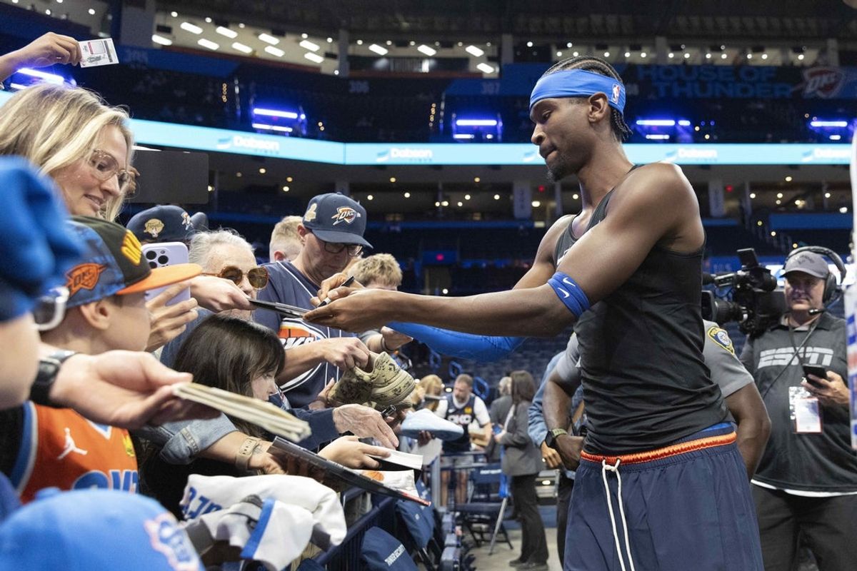 Oklahoma City Thunder guard Shai Gilgeous-Alexander (2) signs his autograph for fans before a game against the Denver Nuggets at Paycom Center.