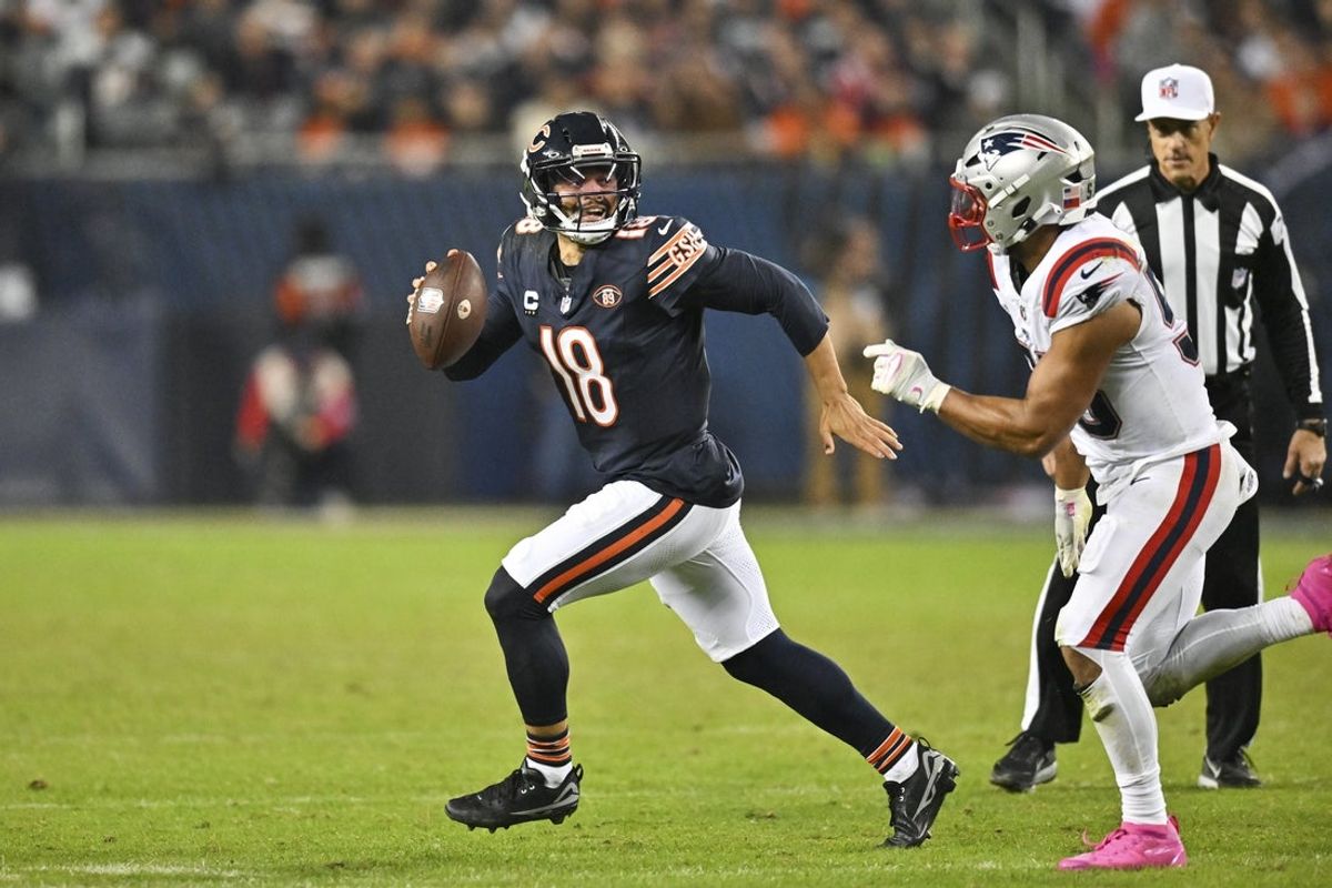 Oct 22, 2026; Chicago, Illinois, USA; Chicago Bears quarterback Caleb Williams (18) scrambles against New England Patriots linebacker Christian Elliss (53) during the fourth quarter at Soldier Field. Mandatory Credit: Patrick Gorski-Imagn Images
