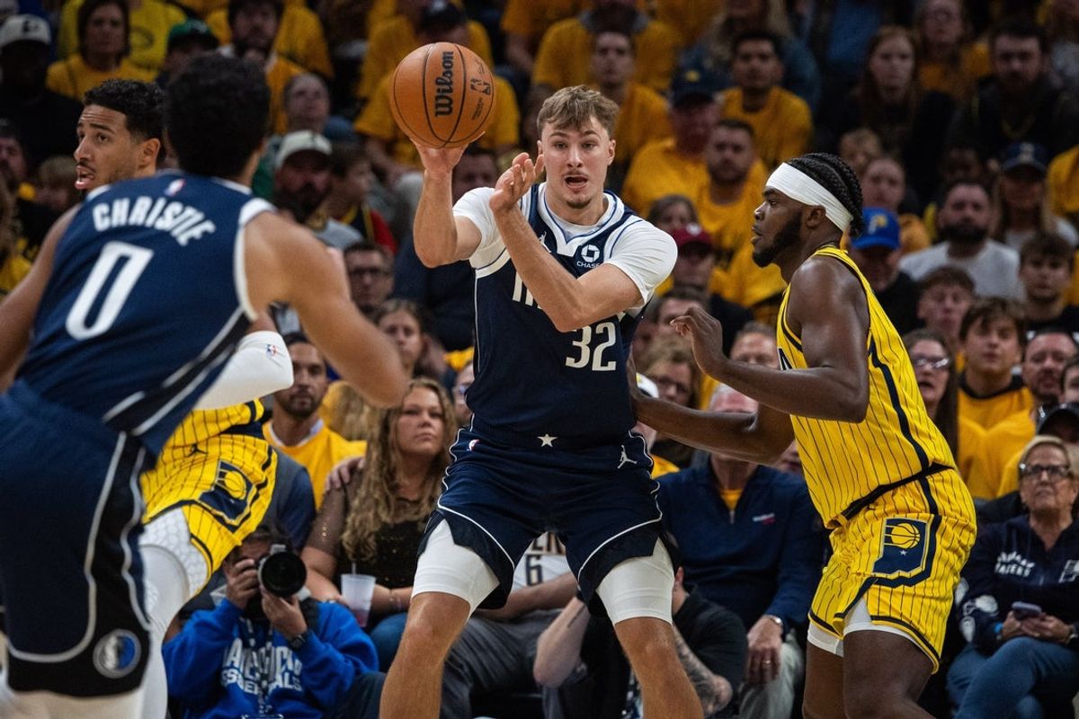 Oct 23, 2026; Indianapolis, Indiana, USA;  Dallas Mavericks forward Cooper Flagg (32) passes the ball while Indiana Pacers forward Jarace Walker (5) defends in the first half at Gainbridge Fieldhouse.  Mandatory Credit: Trevor Ruszkowski-Imagn Images