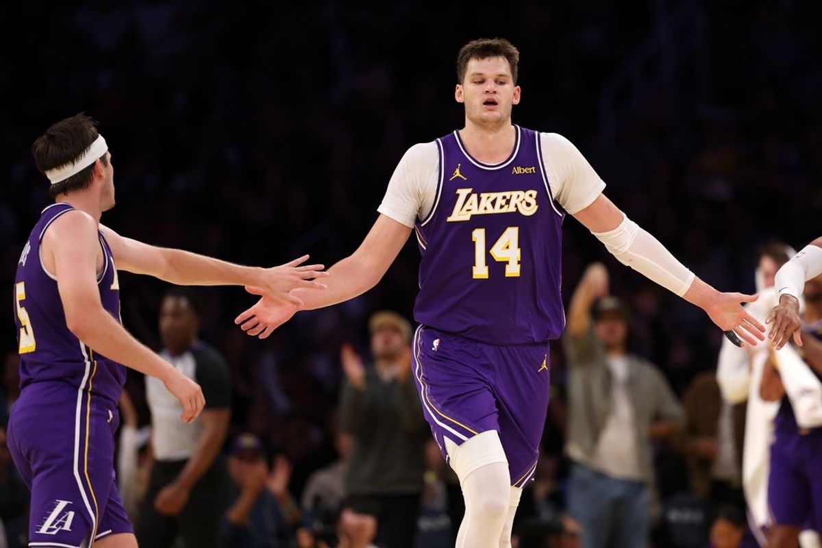 Los Angeles Lakers center Walker Kessler (14) is greeted by guard Austin Reaves (15) during the fourth quarter against the Los Angeles Clippers at Crypto.com Arena.