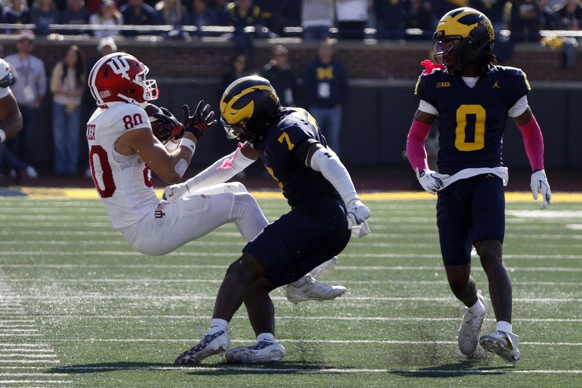 Oct 24, 2026; Ann Arbor, Michigan, USA;  Michigan Wolverines safety Chris Bracy (7) lays a hard hit on Indiana Hoosiers wide receiver Charlie Becker (80) during the first half at Michigan Stadium.  Mandatory Credit: Brian Bradshaw Sevald-Imagn Images