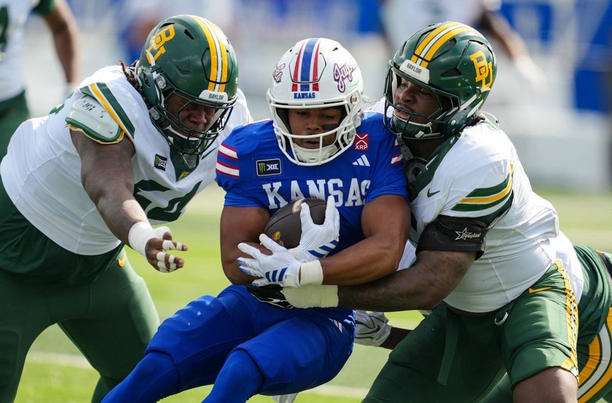 Oct 24, 2026; Lawrence, Kansas, USA; Kansas Jayhawks running back Dylan Edwards (1) runs the ball against Baylor Bears defensive lineman Jae'lin Battle (54) and linebacker Travion Barnes (5) during the first half at David Booth Kansas Memorial Stadium. Mandatory Credit: Jay Biggerstaff-Imagn Images