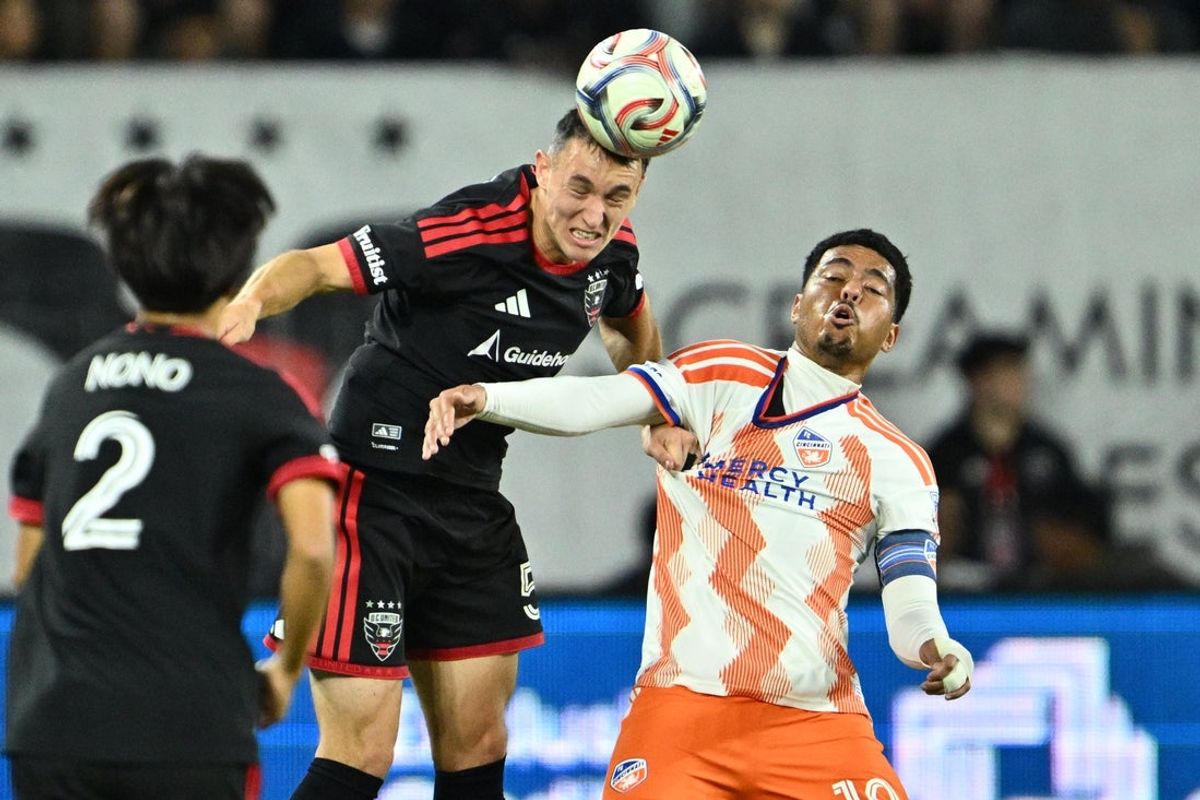 Oct 24, 2026; Washington, District of Columbia, USA;  DC United defender Silvan Hefti (5) heads the ball away from FC Cincinnati midfielder Evander (10) in the first half at Audi Field. Mandatory Credit: Jamie Sabau-Imagn Images