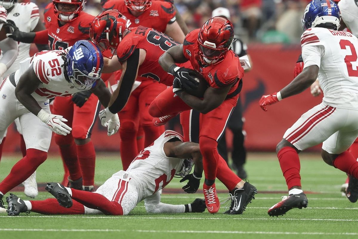 Oct 25, 2026; Houston, Texas, USA; Houston Texans running back Woody Marks (4) runs with the ball as New York Giants safety Jason Pinnock (25) attempts to make a tackle during the second quarter at Reliant Stadium. Mandatory Credit: Troy Taormina-Imagn Images