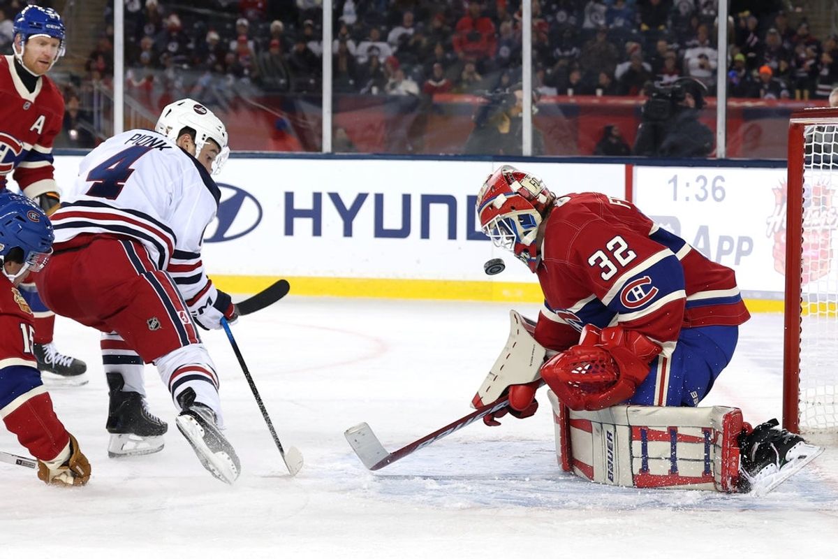 Oct 25, 2026; Winnipeg, Manitoba, CAN;  Winnipeg Jets defenseman Neal Pionk (4) shoots on Montreal Canadiens goaltender Jacob Fowler (32) in the third period during the 2026 Heritage Classic ice hockey game at Princess Auto Stadium.  Mandatory Credit: James Carey Lauder-Imagn Images