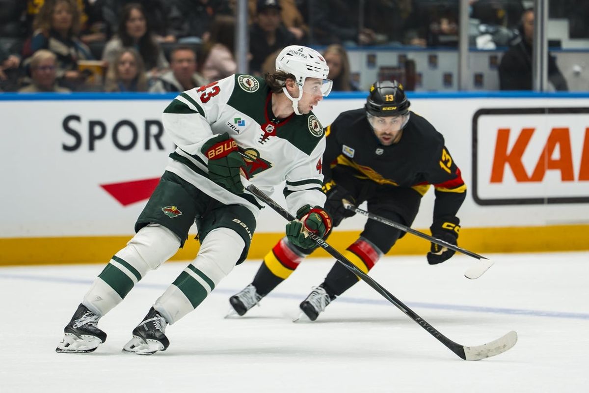 Oct 25, 2026; Vancouver, British Columbia, CAN;  Vancouver Canucks forward Arshdeep Bains (13) pursues Minnesota Wild defenseman Quinn Hughes (43) in the second period at Rogers Arena.  Mandatory Credit: Bob Frid-Imagn Images